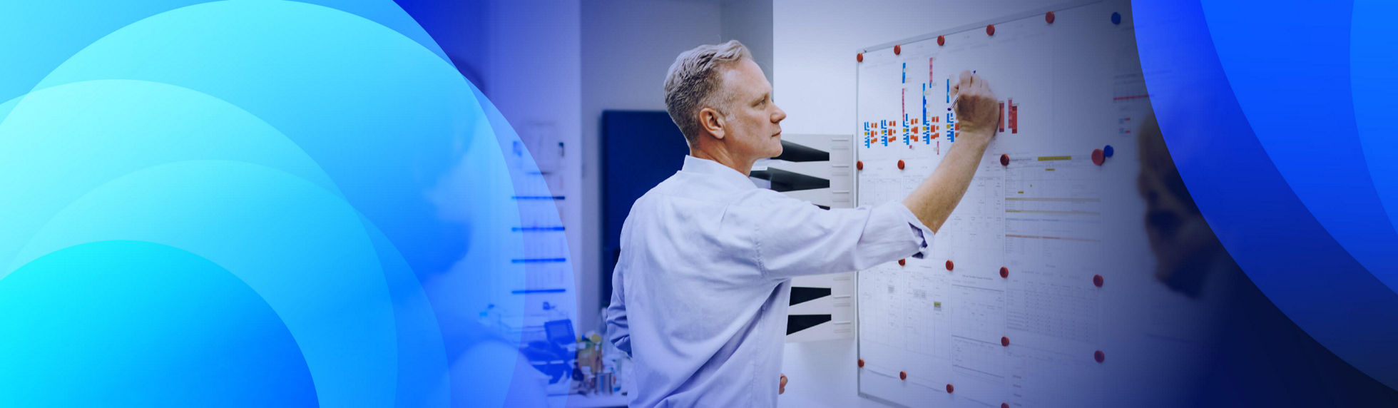 A man writing on a whiteboard in a team meeting