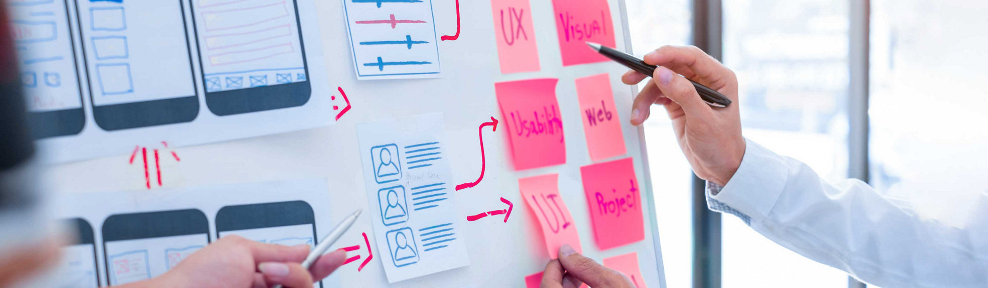 A man writing on pink sticky notes