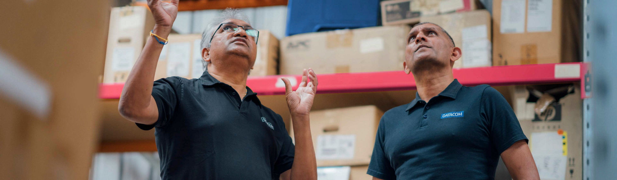 Two Datacom warehouse working having a discussion about stock