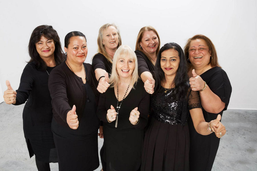 Group of women who are Farmers department store staff stood smiling and giving thumbs up. 