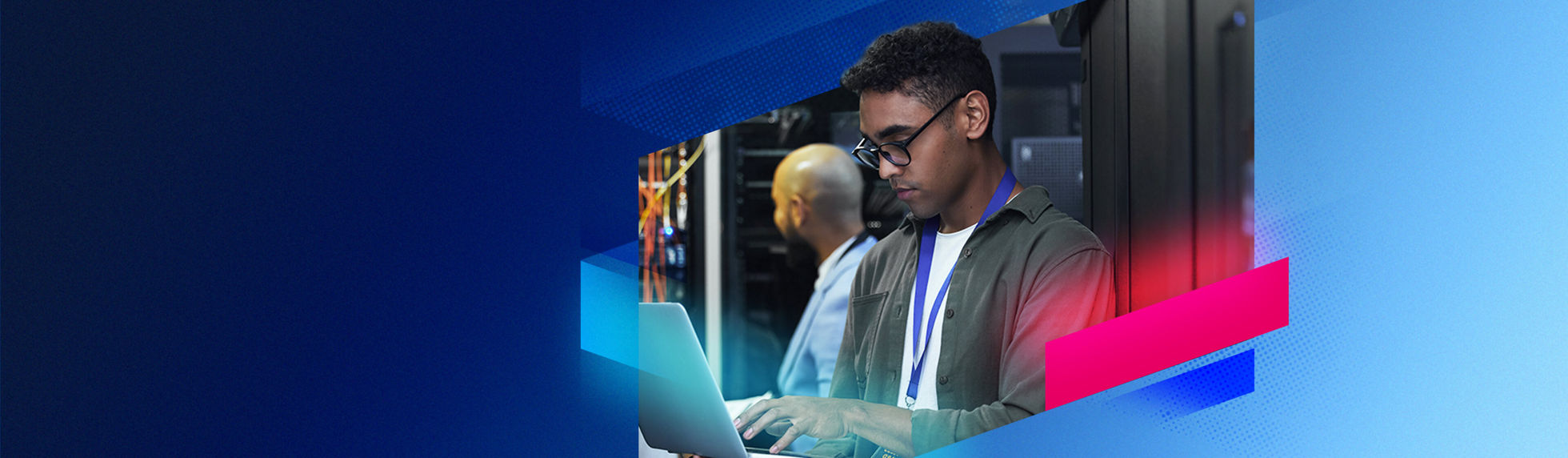 An IT expert using a computer in dark server room