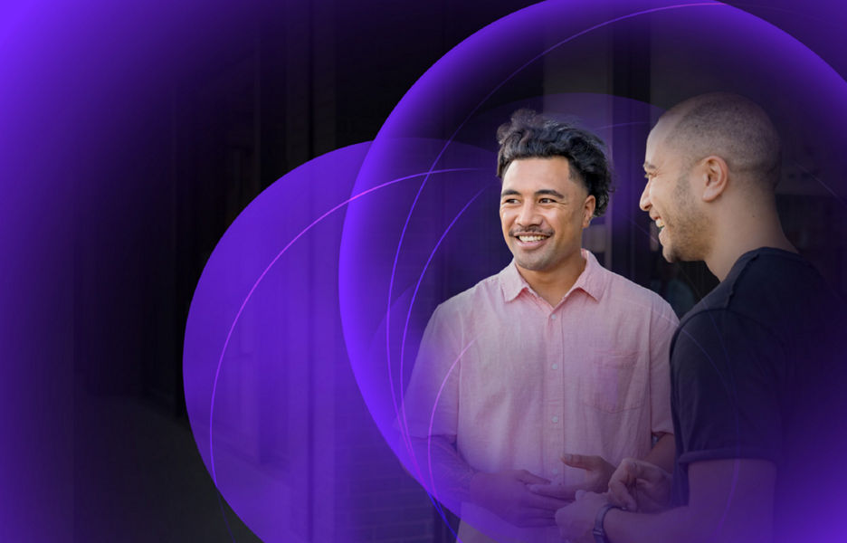 Two men having a conversation and smiling while standing outside