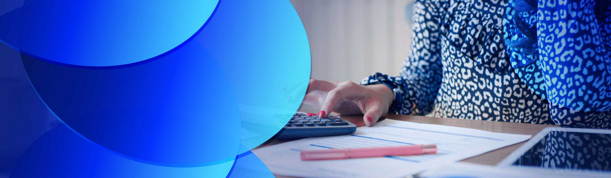 Woman using a calculator on a wooden desk