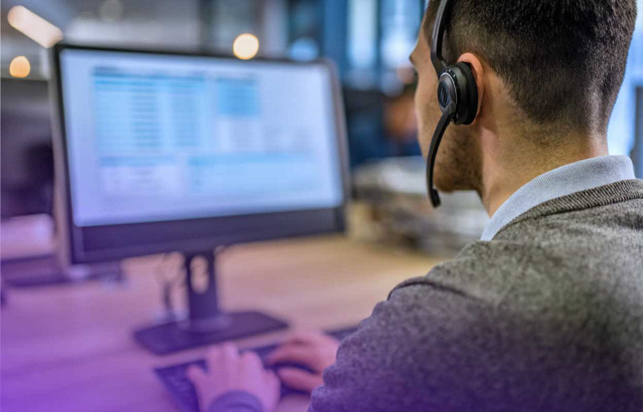Man with headset on working on a moniter