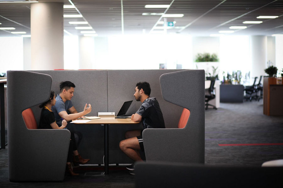 three people collaborating at a workstation