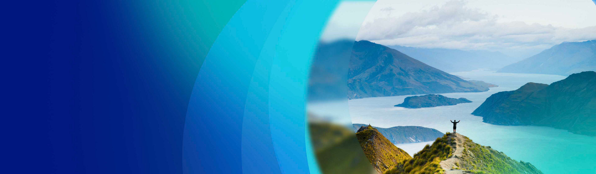 Person standing on a hill overlooking a scenic fjord