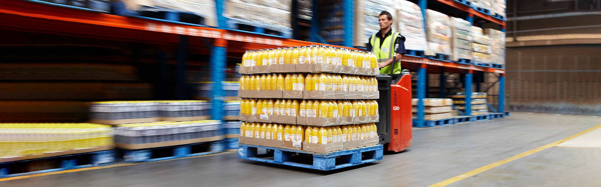 Warehouse worker transporting a blue pallet