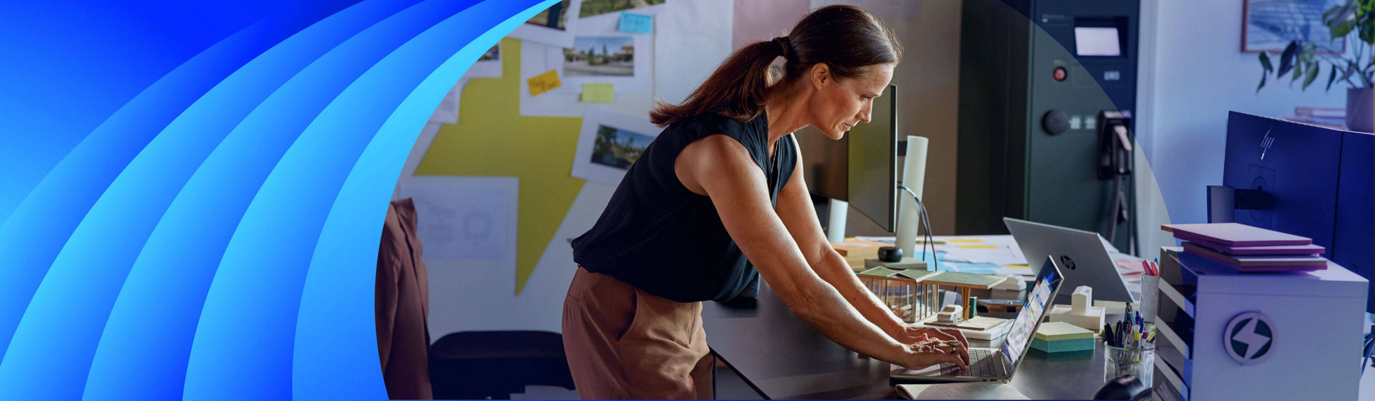 A women working on a HP laptop at her desk standing up