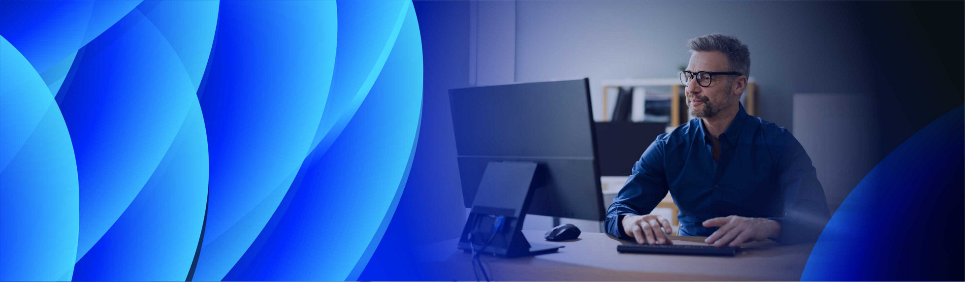 A smiling man working at a computer