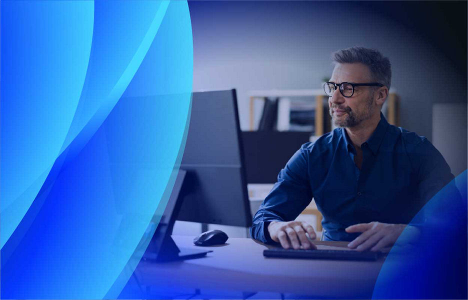 A smiling man working at a computer