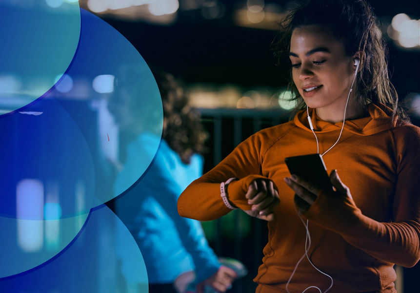 A young female using a smartphone and looking at her smartwatch after exercising.