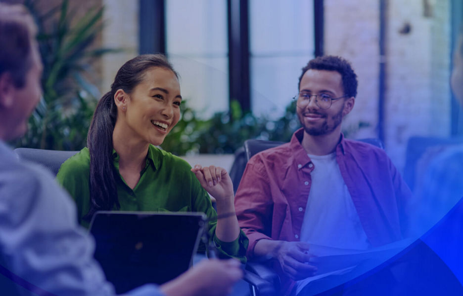 A group of happy professionals having a discussion in an open space with plants in the background