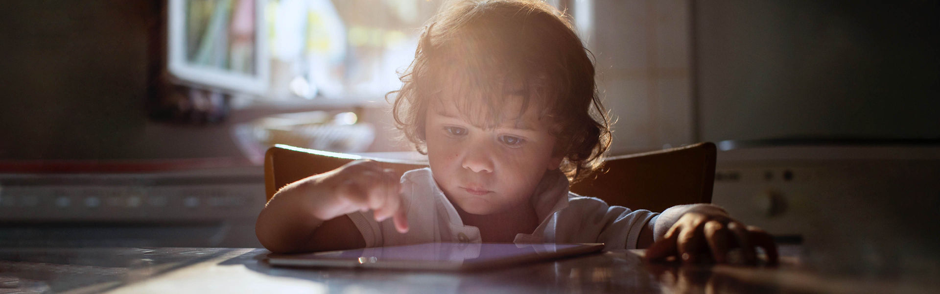 Young child interacting with a digital tablet