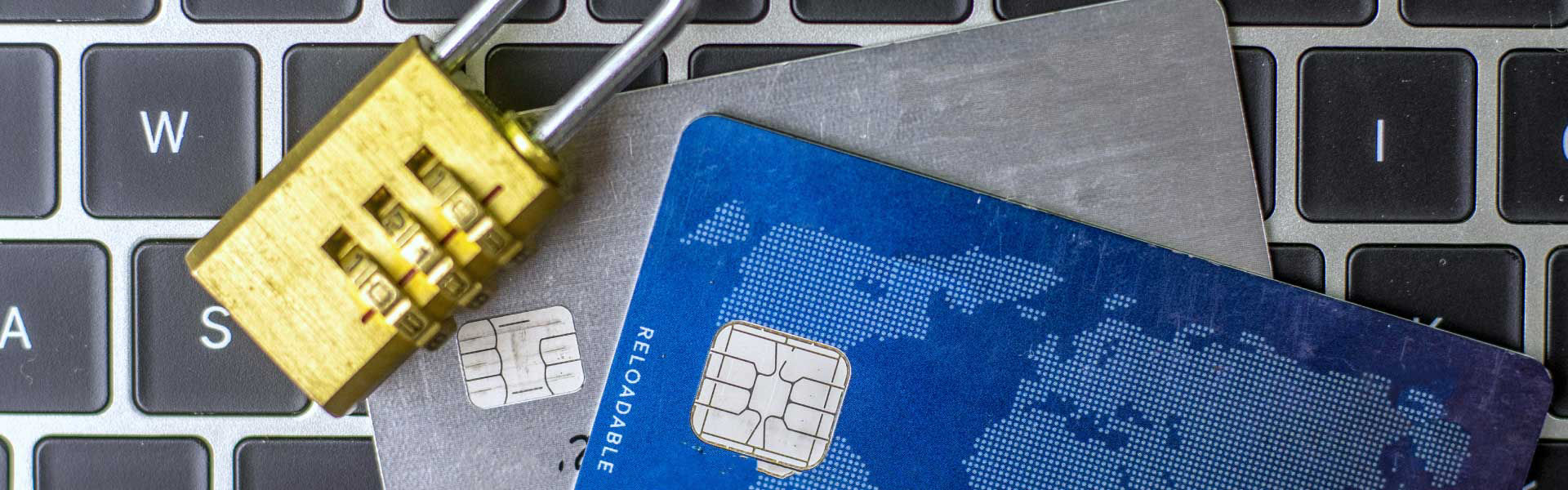 Credit cards and a lock sitting on top of a laptop keyboard
