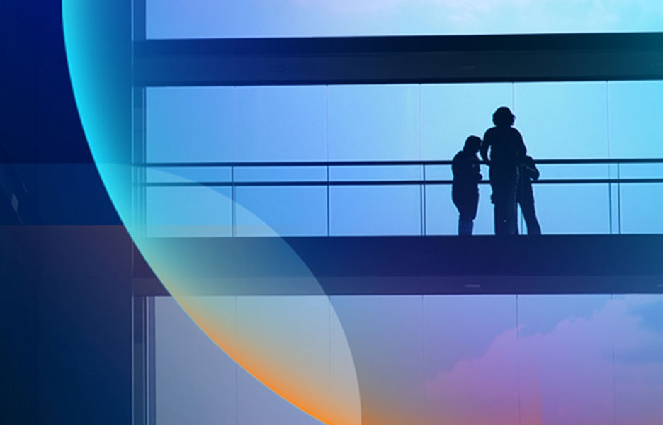 Silhouette of people standing on the bridge of a big glass corporate building