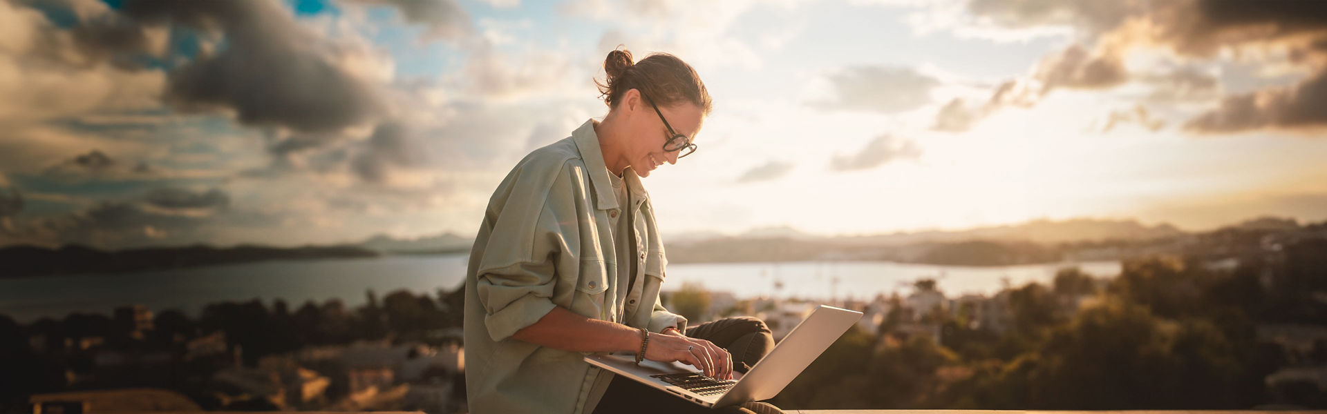 Woman holding laptop with a scenic background