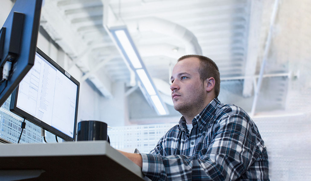 Man in an office looking at computer screens