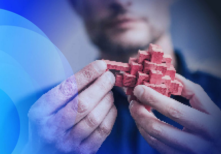 A man holding a pink wooden puzzle and sliding a block into place