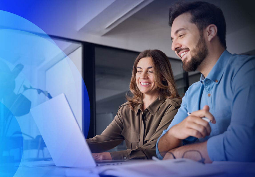 Two professionals reviewing insights infront of a laptop