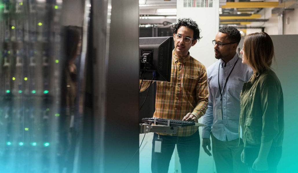 IT professionals reviewing information on a monitor in a server room