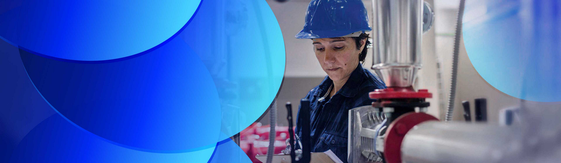A woman taking notes on a clipboard surrounded by heavy machinery