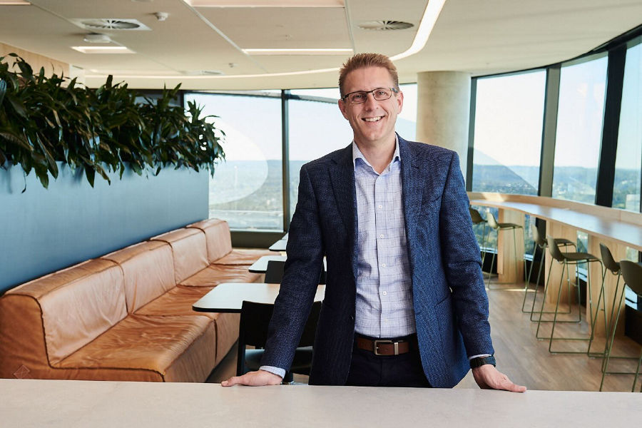 Photograph of Mark Hile standing in front a table