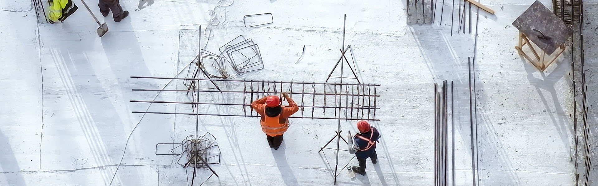 Aerial view of workers working with concrete in large open space