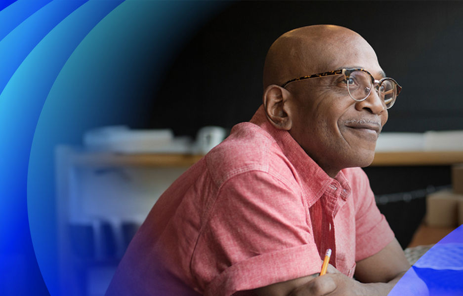 A man with glasses looking up smiling with A banner with Datacom brand pattern overlay