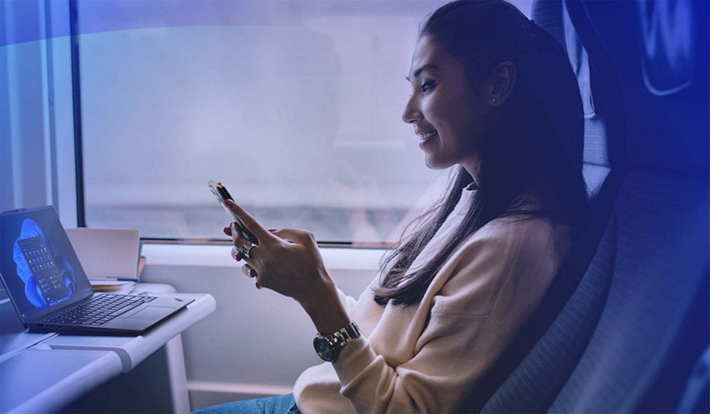 Woman sitting in chair using phone with her laptop open