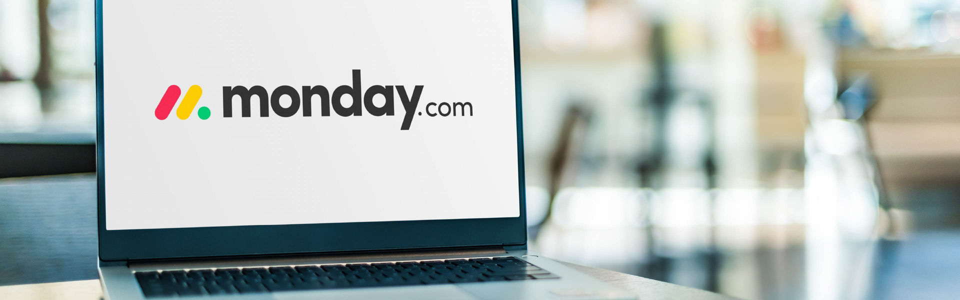 Laptop opened and Monday.com logo is displayed on the screen