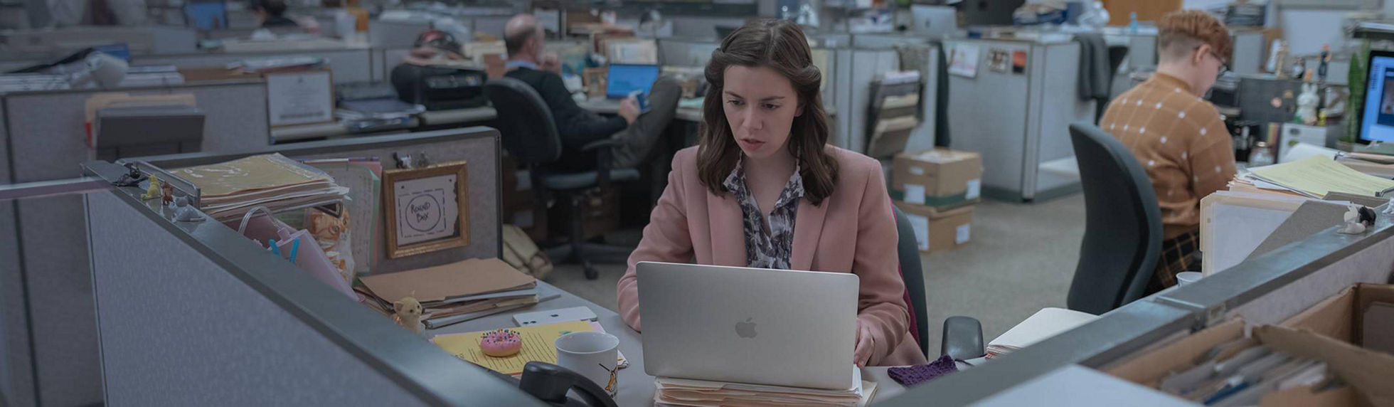 An ladt working at her desk on an Apple device