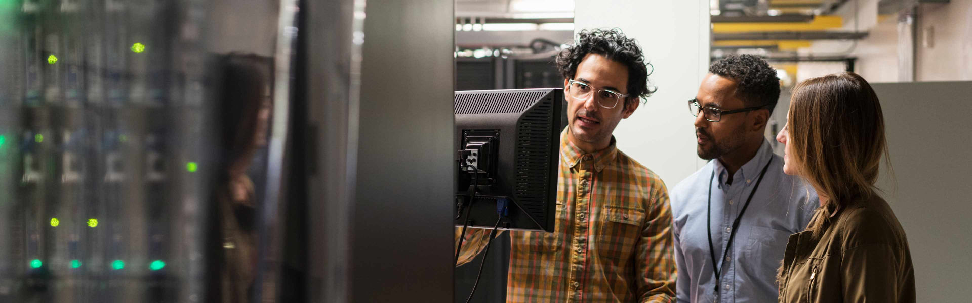  Three employees in a Data Centre looking at a screen