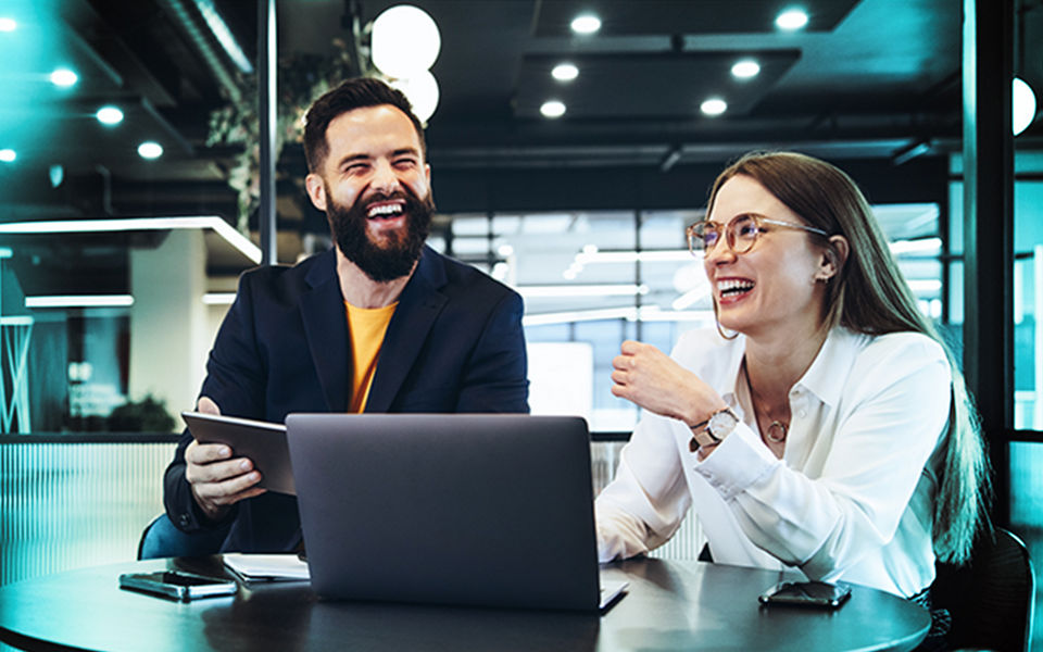 Two happy employees in a meeting a modern office