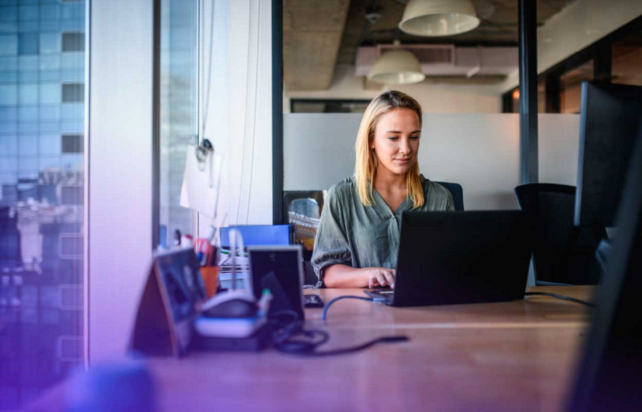 Women in office looking at laptop screen