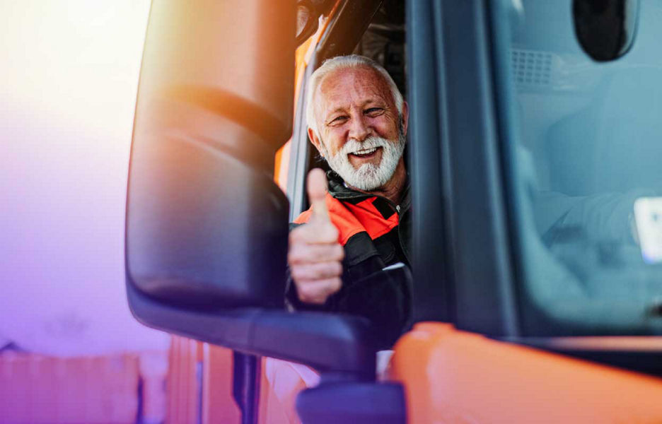 Man in a truck smiling and with his thumbs up