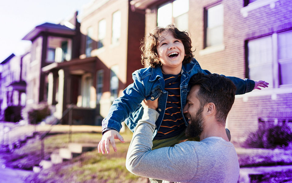 A happy young family outside townhouses