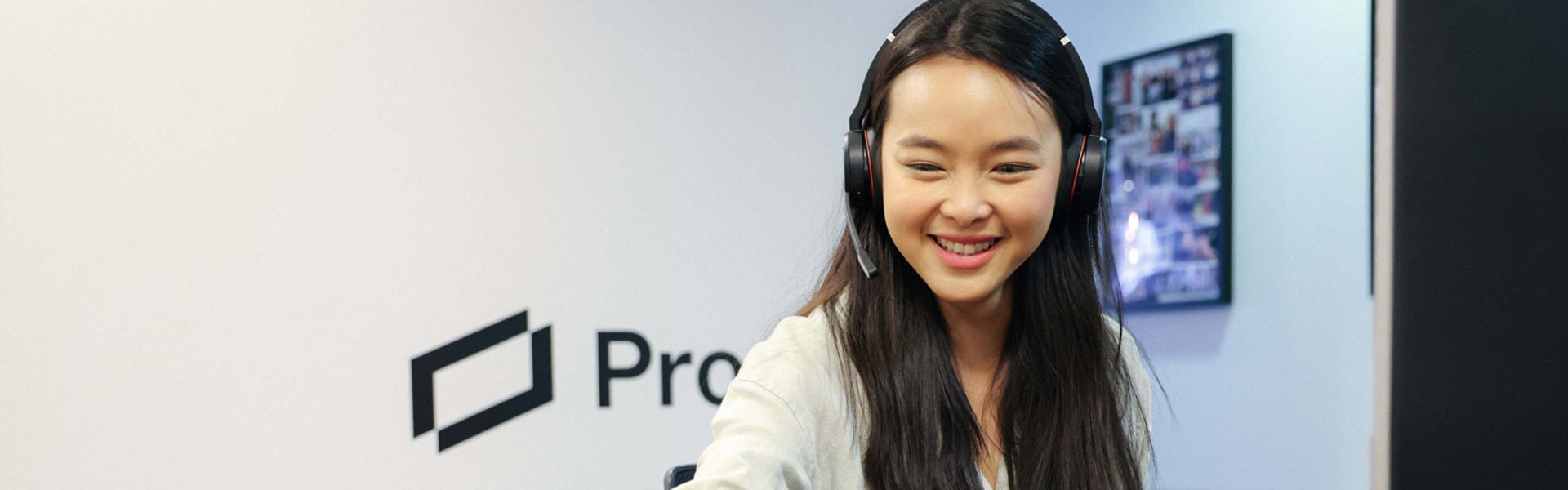 Woman sitting at a desk smiling with a headset