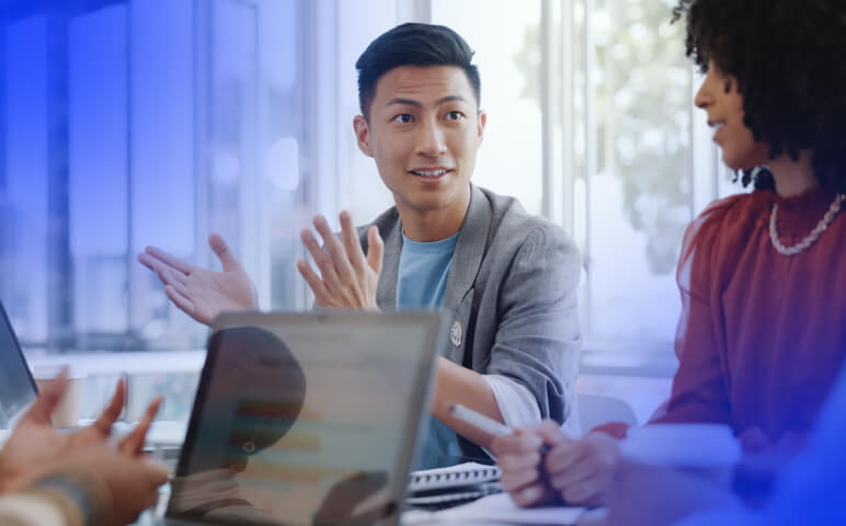 Man and woman at desk looking at laptop in office room
