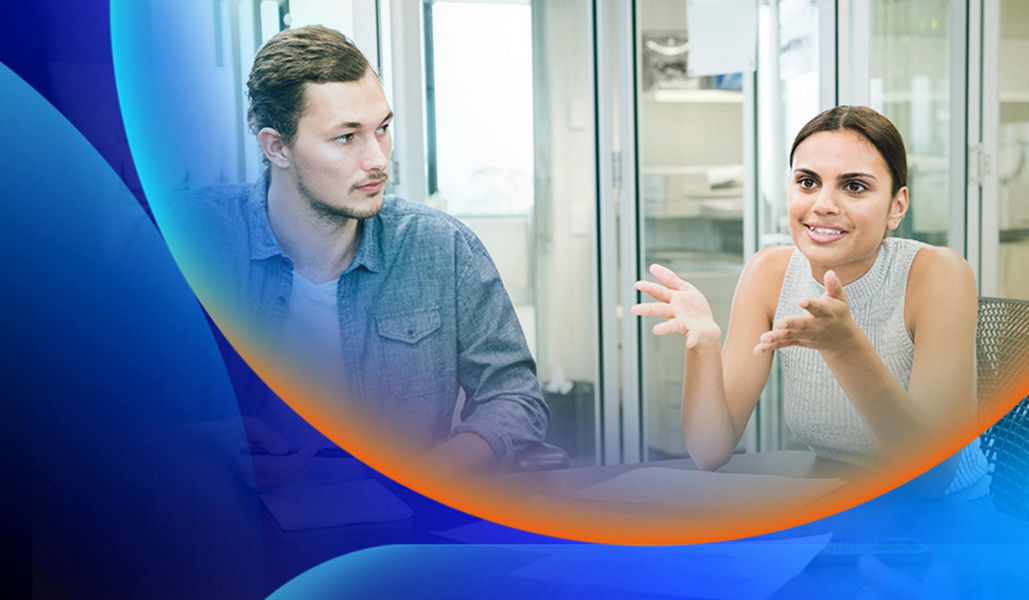 Woman making hand gestures while talking to a group of people sitting down at a table in an office with an orange and blue lens overlay