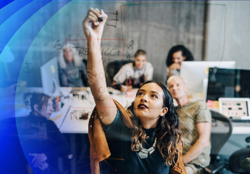 A women explaining strategy to colleagues while writing on glass
