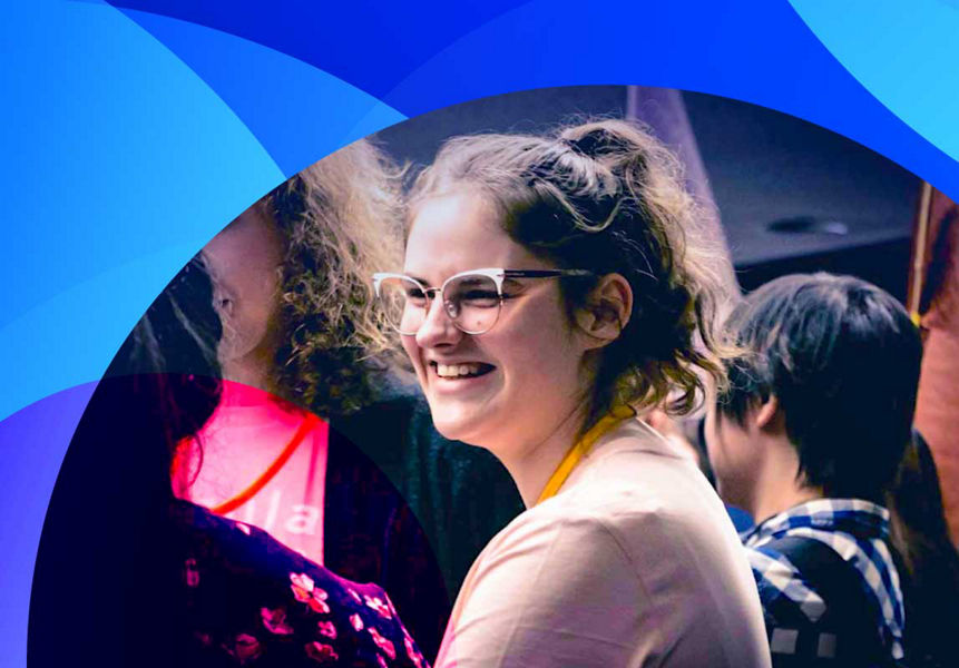A female graduate talking amongst other graduates at a Datacom workshop