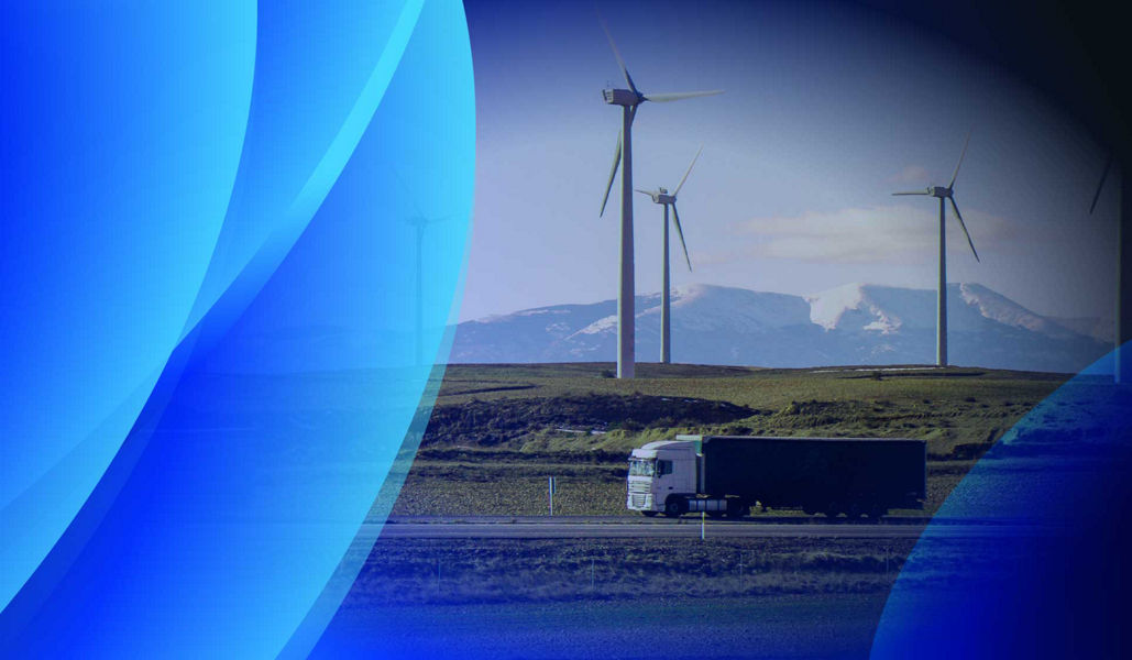 A logistics truck driving alongside a sustainable wind farm