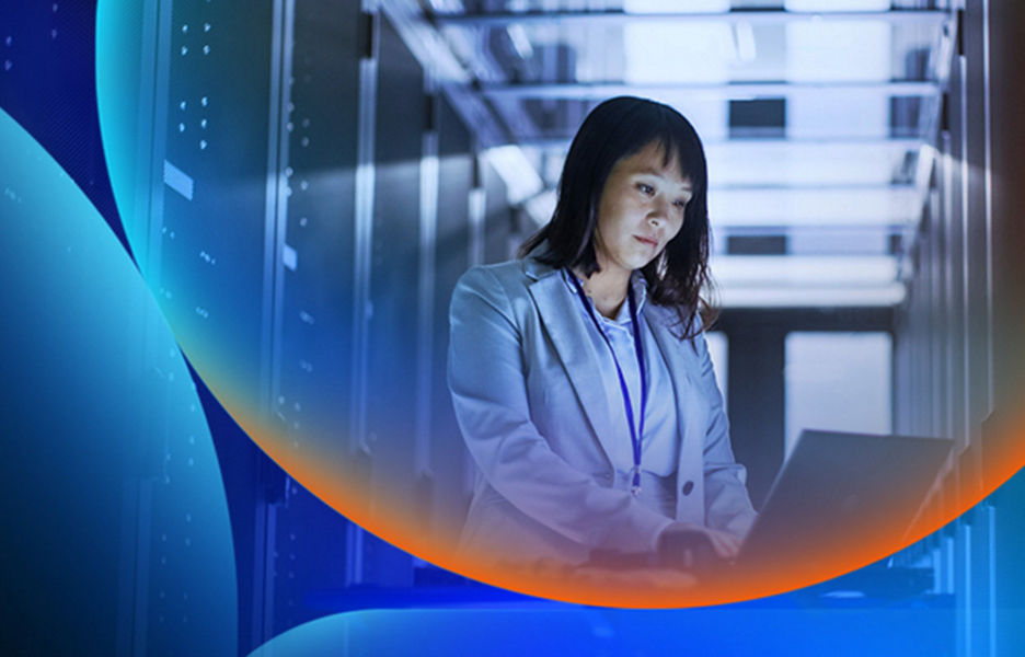 A woman working on a laptop in a dark room with servers with an orange and blue lens overlay