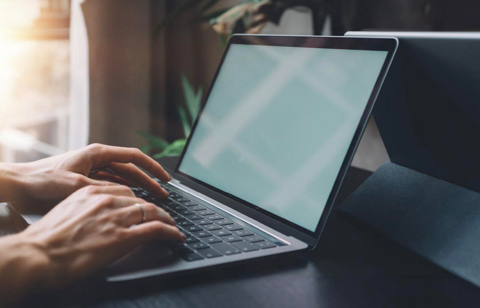 Hands typing on laptop