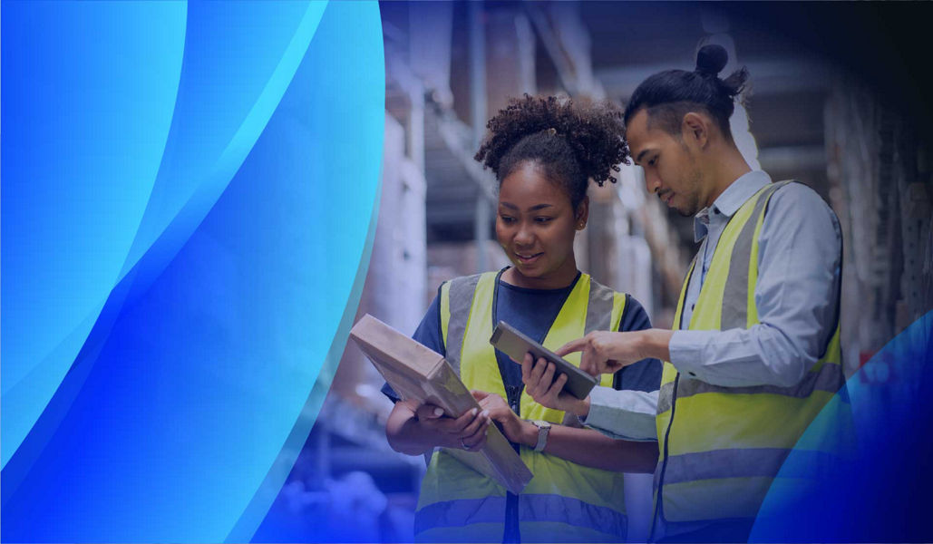 Two workers reviewing software licensing on a tablet in a warehouse