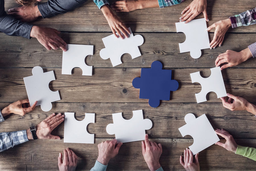 Hands assembling jigsaw puzzle