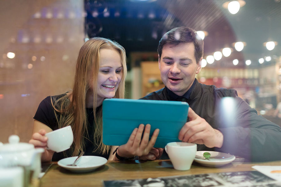People having coffee and looking at a tablet