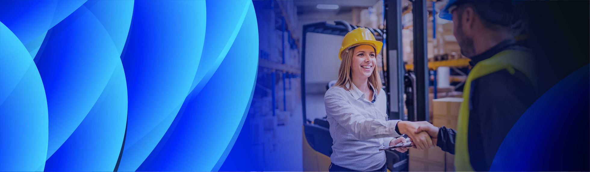 A smiling woman shaking hands with a supplier in a warehouse