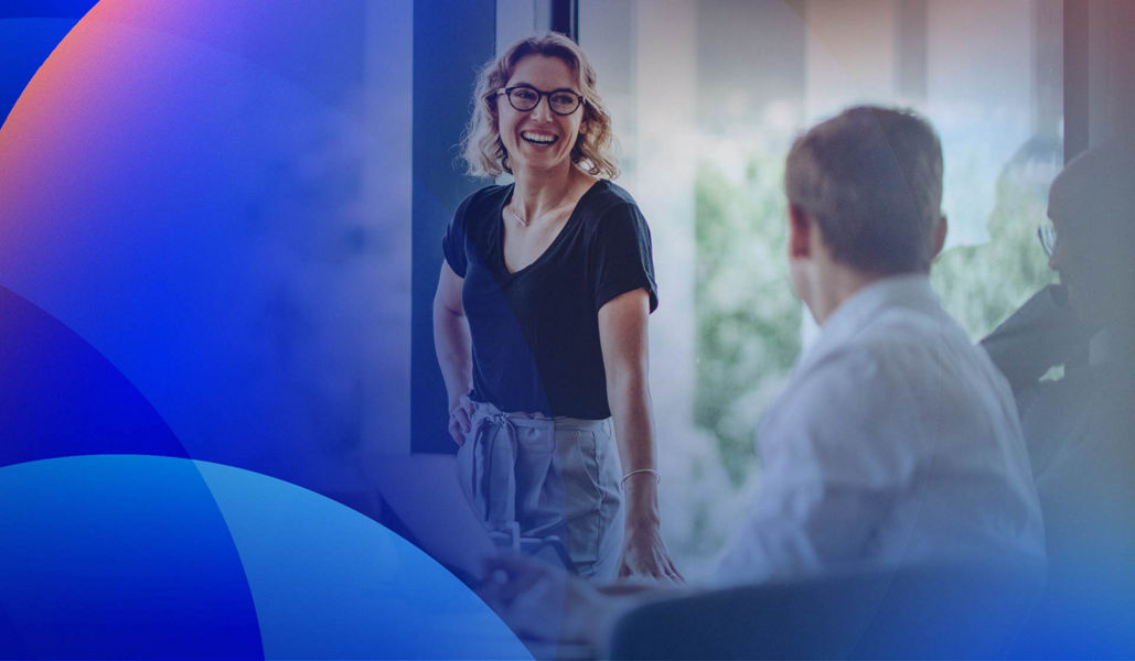 A female professional engaging with colleagues in a meeting room.