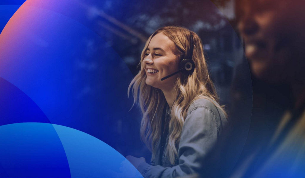 Smiling contact centre agents wearing a headset and providing customer service support.